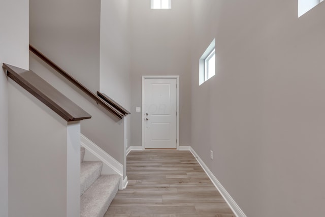 stairs featuring a towering ceiling and hardwood / wood-style floors