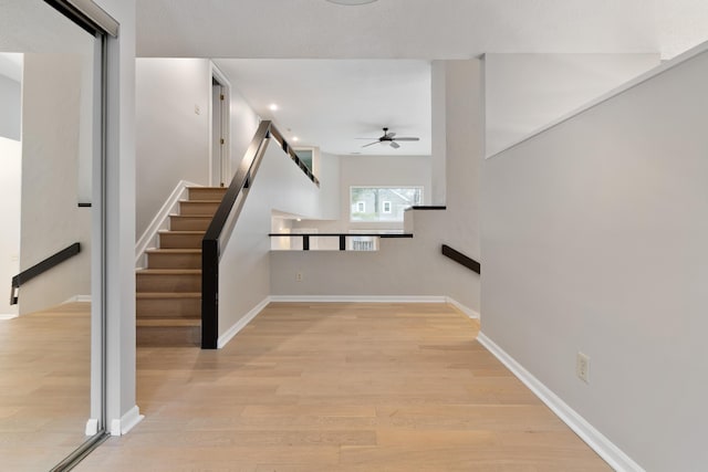 stairway with ceiling fan and hardwood / wood-style floors