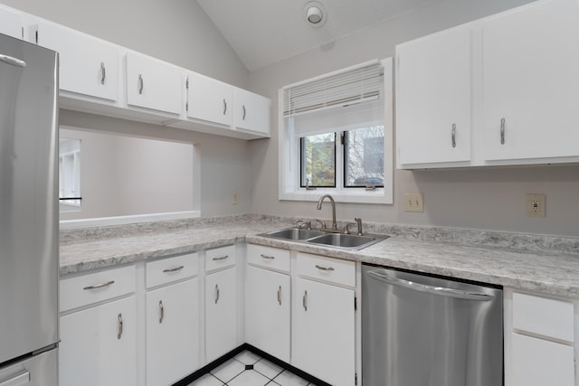 kitchen with white cabinetry, sink, stainless steel appliances, and vaulted ceiling