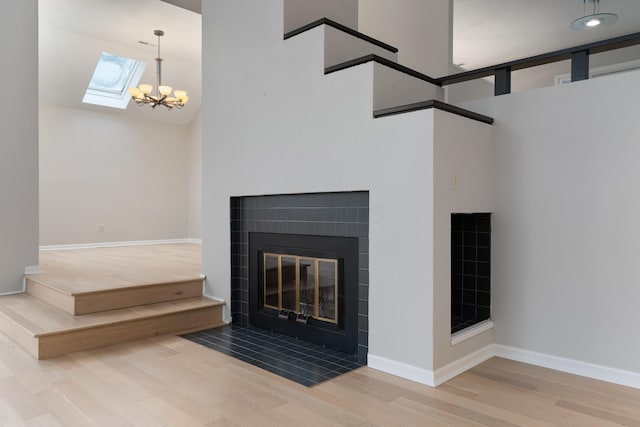 unfurnished living room featuring wood-type flooring, a high ceiling, and an inviting chandelier