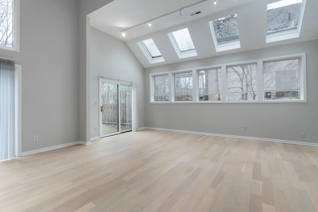 spare room featuring rail lighting, light hardwood / wood-style flooring, and lofted ceiling