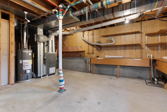 basement with a workshop area, heating unit, and gas water heater