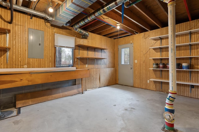 basement with electric panel and wood walls