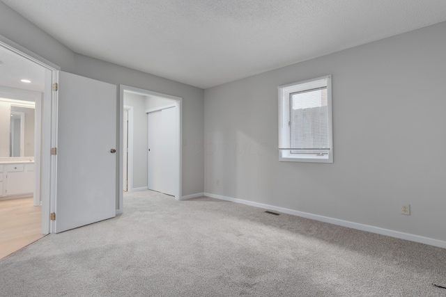 carpeted spare room with a textured ceiling