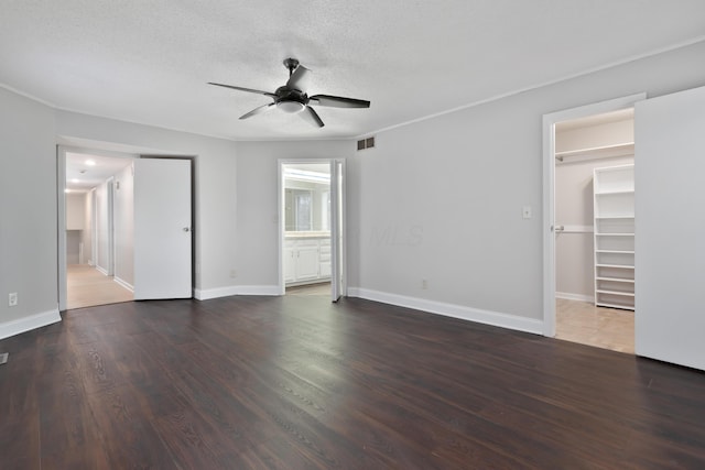 unfurnished room with ceiling fan, dark hardwood / wood-style floors, and a textured ceiling