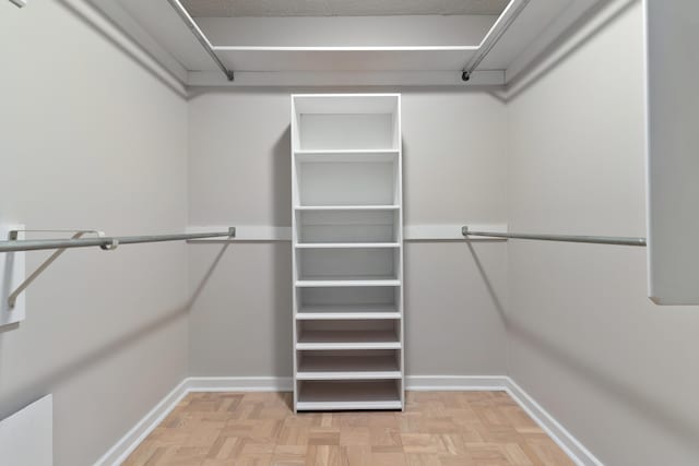 walk in closet with light parquet flooring