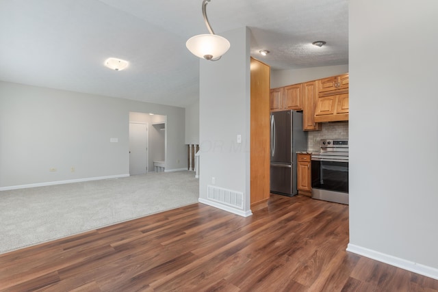 kitchen featuring lofted ceiling, dark hardwood / wood-style floors, a textured ceiling, appliances with stainless steel finishes, and tasteful backsplash