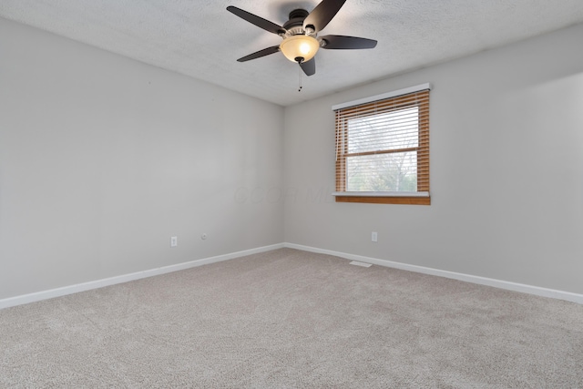 carpeted empty room featuring ceiling fan and a textured ceiling