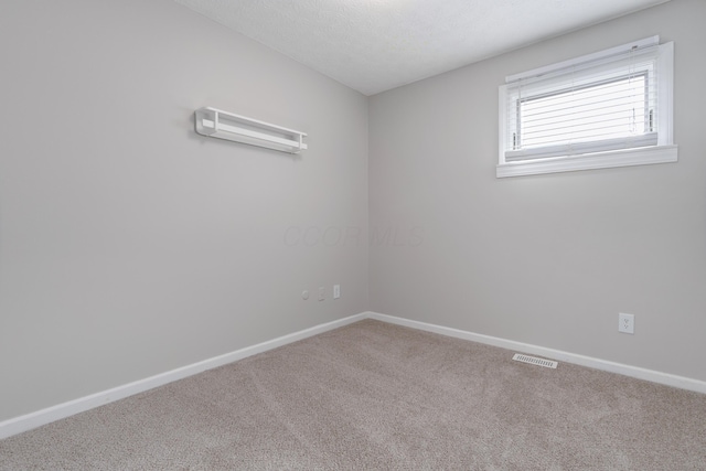 empty room with carpet flooring and a textured ceiling