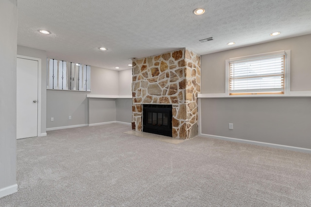 unfurnished living room featuring a fireplace, a textured ceiling, and carpet floors