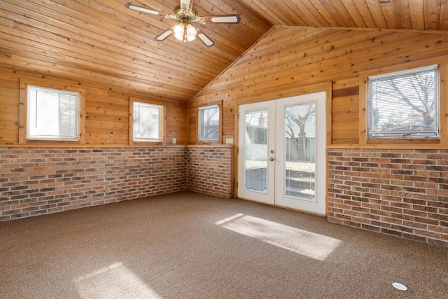 unfurnished room featuring a healthy amount of sunlight, french doors, and brick wall