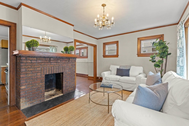 living room featuring an inviting chandelier, a brick fireplace, dark wood-type flooring, and crown molding