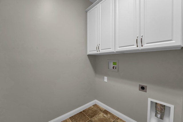 washroom featuring washer hookup, cabinets, dark tile patterned floors, and hookup for an electric dryer