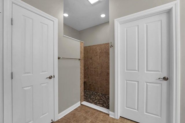 bathroom with tile patterned flooring and tiled shower