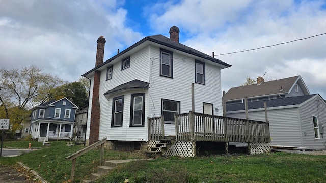 back of house featuring a deck and a yard