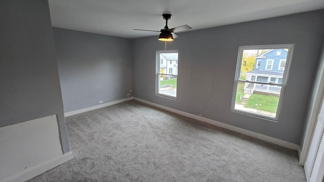 spare room featuring plenty of natural light, ceiling fan, and light carpet