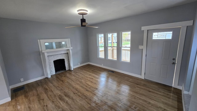 unfurnished living room featuring ceiling fan, a fireplace, and dark hardwood / wood-style floors