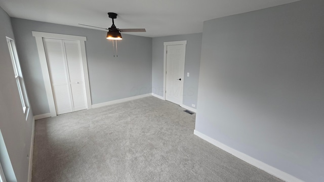 unfurnished bedroom featuring light carpet, a closet, and ceiling fan