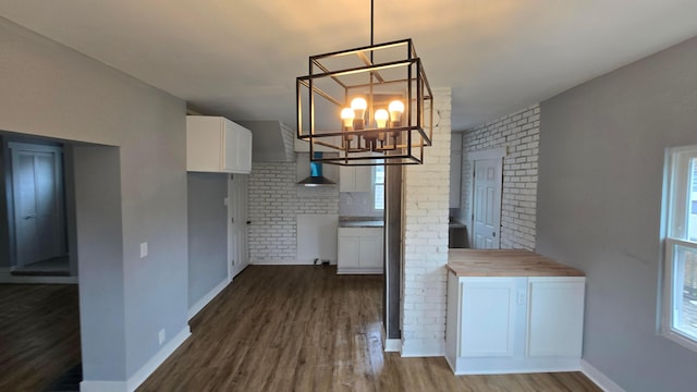 kitchen with butcher block counters, hanging light fixtures, a notable chandelier, hardwood / wood-style floors, and white cabinets