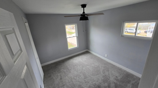 unfurnished room with ceiling fan, plenty of natural light, carpet floors, and vaulted ceiling