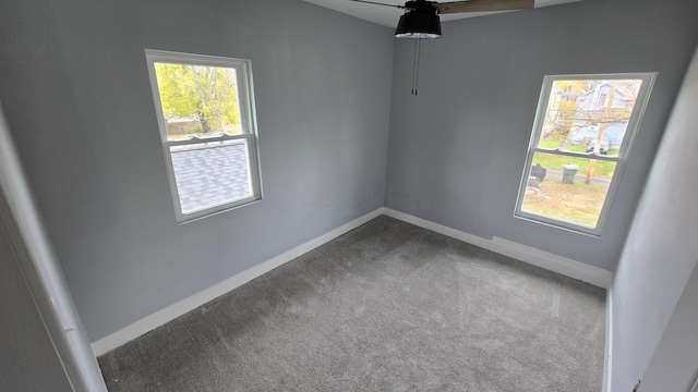 empty room with dark carpet and ceiling fan