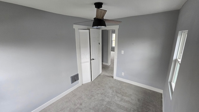 unfurnished room featuring light carpet and ceiling fan