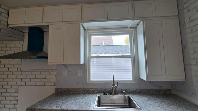 kitchen featuring white cabinets, sink, wall chimney exhaust hood, and ornamental molding