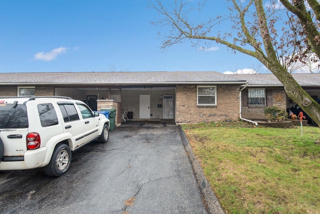 ranch-style home with a carport and a front yard