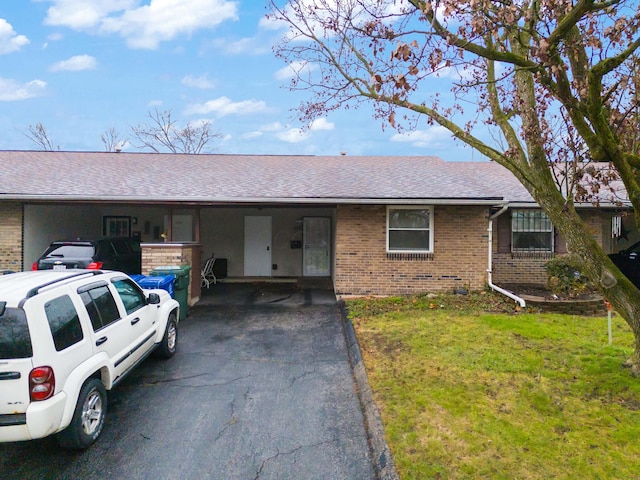 ranch-style home featuring a carport and a front yard