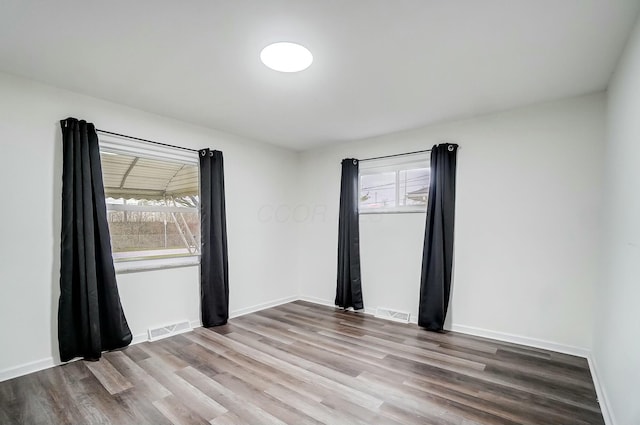 spare room with a wealth of natural light and light hardwood / wood-style flooring