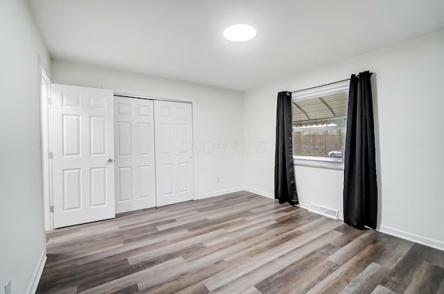 unfurnished bedroom with a closet and hardwood / wood-style floors