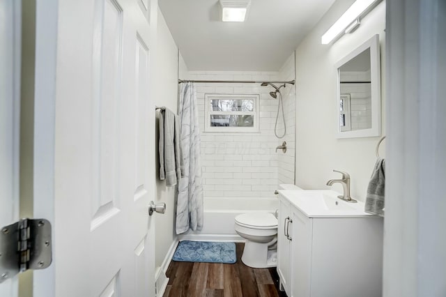 full bathroom featuring hardwood / wood-style flooring, vanity, shower / bath combination with curtain, and toilet