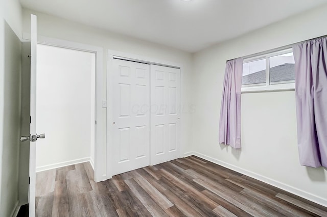 unfurnished bedroom featuring a closet and dark hardwood / wood-style floors