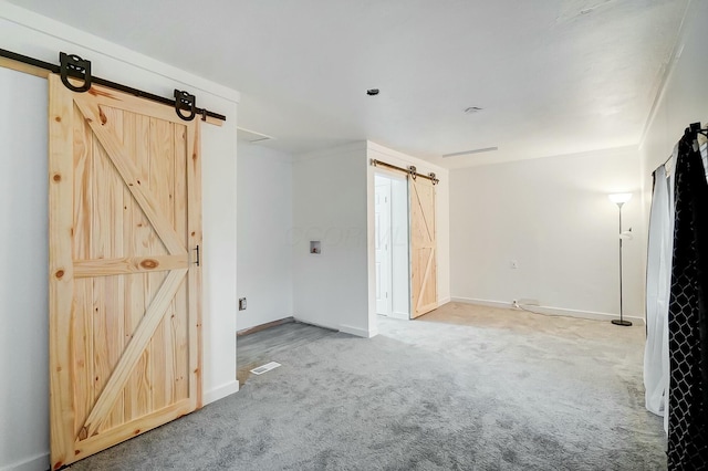 carpeted spare room featuring a barn door