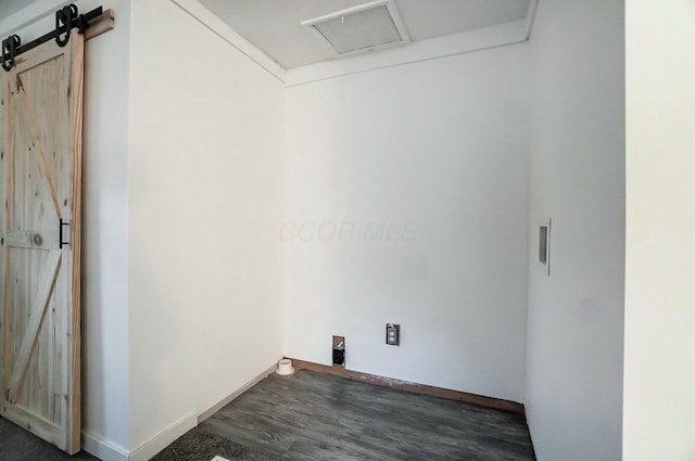 laundry area featuring dark hardwood / wood-style flooring and a barn door