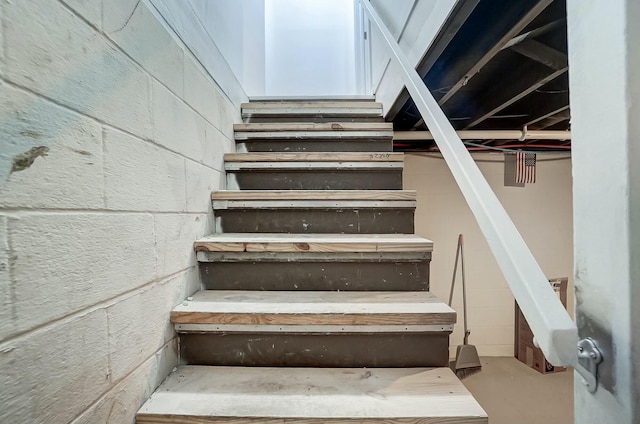 stairs featuring concrete flooring