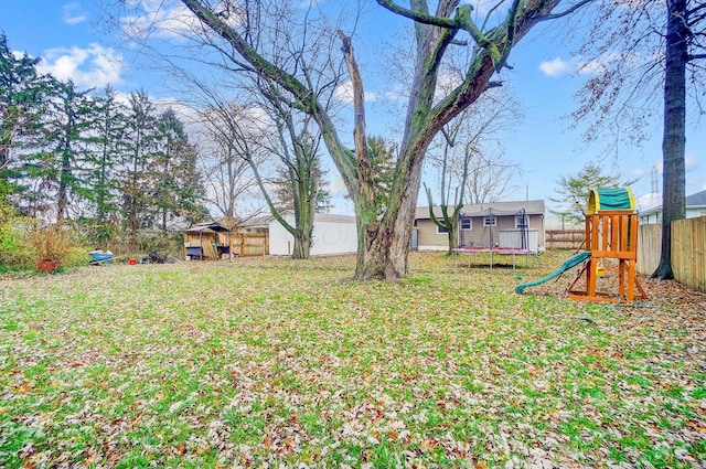 view of yard with a playground and a trampoline