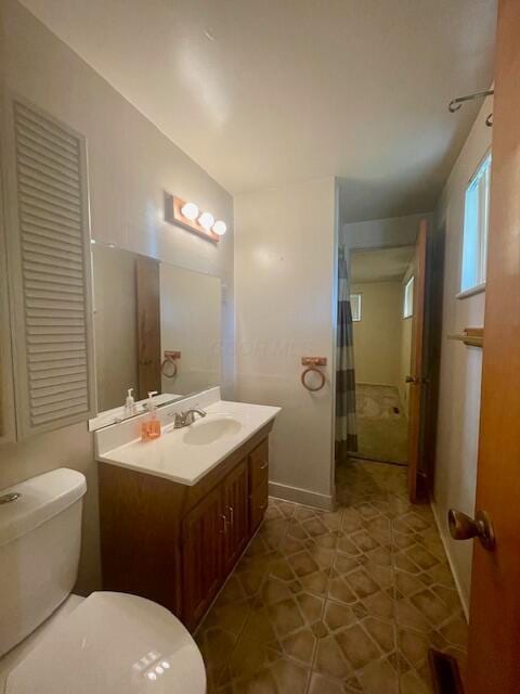 bathroom featuring tile patterned flooring, vanity, and toilet