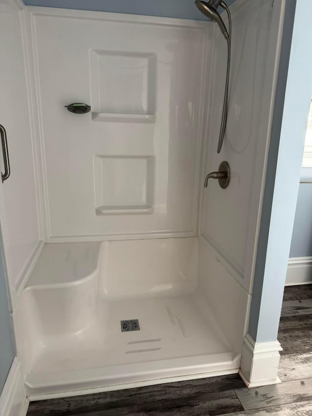 bathroom with hardwood / wood-style flooring and walk in shower