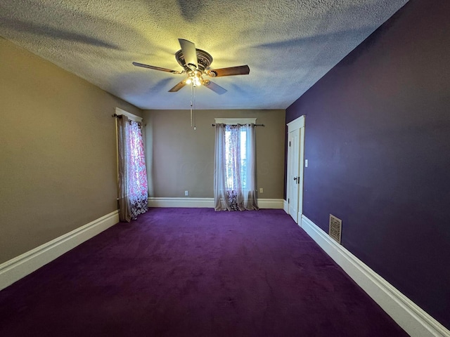 carpeted spare room with a textured ceiling and ceiling fan