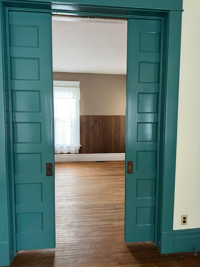 entrance foyer with wood walls and hardwood / wood-style flooring