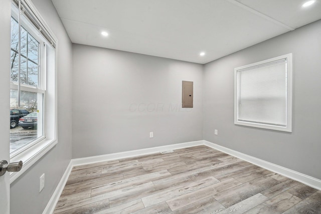 spare room featuring light wood-type flooring and electric panel