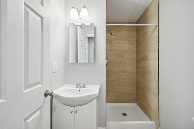 bathroom featuring tiled shower and vanity