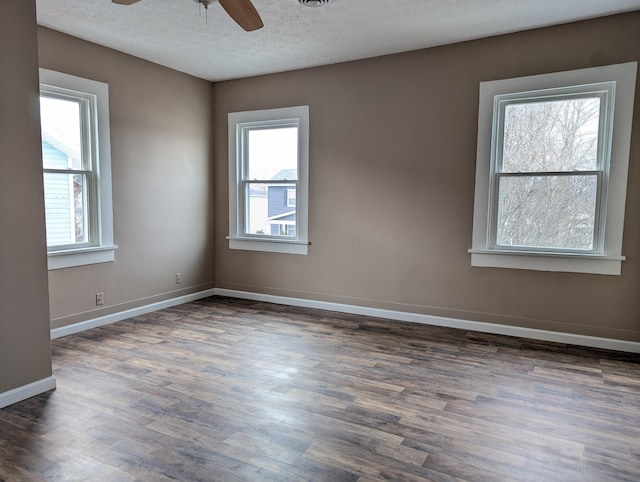 unfurnished room with ceiling fan, dark wood-type flooring, and a textured ceiling