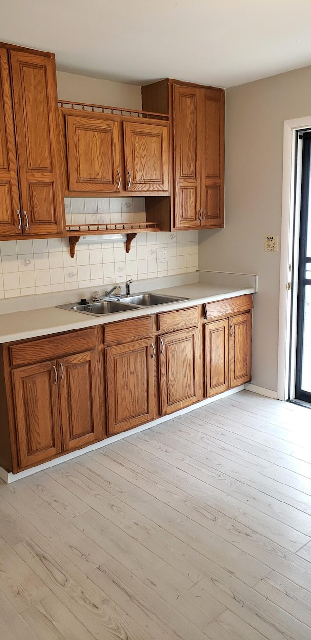 kitchen with decorative backsplash, sink, and light hardwood / wood-style floors