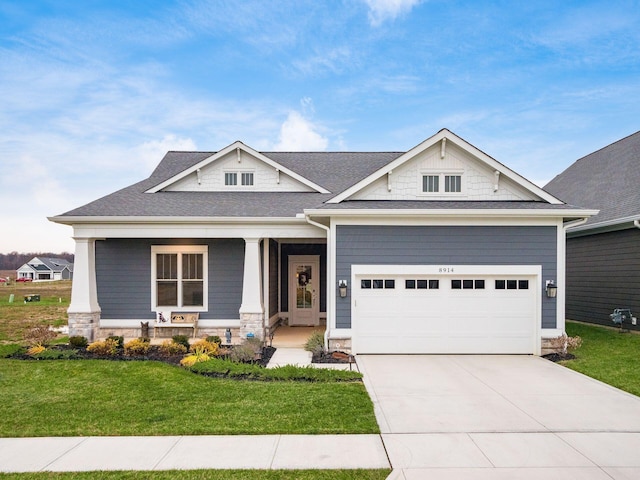 craftsman house featuring covered porch, a front lawn, and a garage