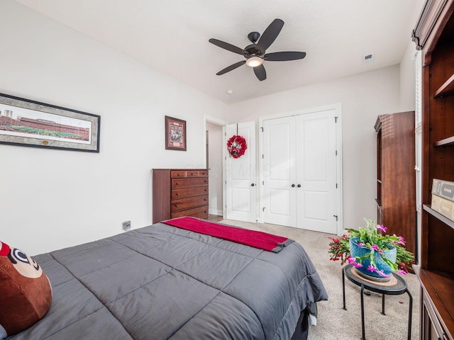 bedroom with ceiling fan, a closet, and light carpet