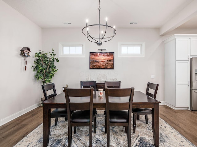 dining area featuring dark hardwood / wood-style flooring, plenty of natural light, and a chandelier