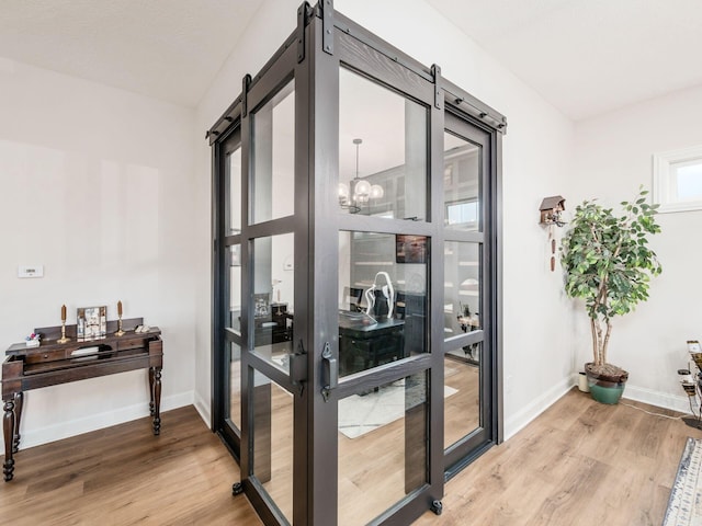 entryway featuring a notable chandelier, a barn door, and hardwood / wood-style floors