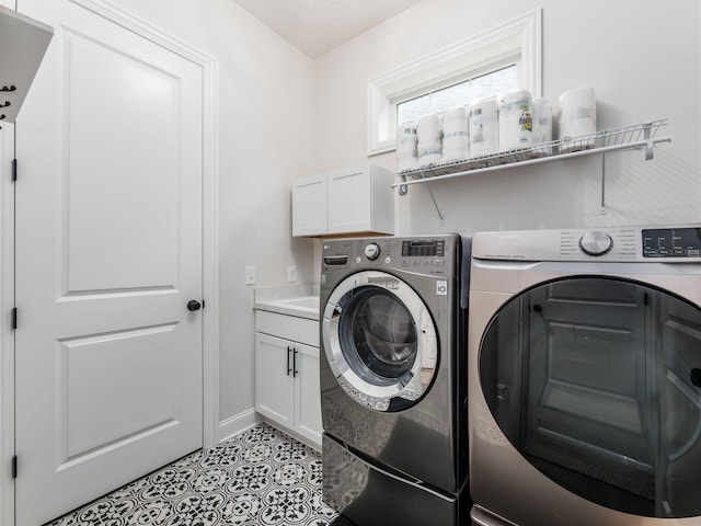 laundry room with washer and dryer, light tile patterned flooring, a textured ceiling, and cabinets